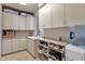Bright laundry room with ample cabinet space and a utility sink at 10751 E Candlewood Dr, Scottsdale, AZ 85255