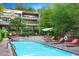 Community pool with lounge chairs and building view at 7157 E Rancho Vista Dr # 3006, Scottsdale, AZ 85251