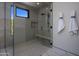 Walk-in shower with glass enclosure and marble floor at 29646 N 109Th Pl # 128, Scottsdale, AZ 85262
