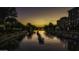 Sunset view of a canal with unique art installations on the water at 7175 E Camelback Rd # 704, Scottsdale, AZ 85251