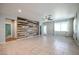 Living area featuring a tile floor, ceiling fan, and wood accent wall at 30948 W Columbus Ave, Buckeye, AZ 85396