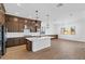 Modern kitchen with dark wood cabinets, white subway tile backsplash, and stainless steel appliances at 37520 W Padilla St, Maricopa, AZ 85138