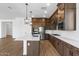 Modern kitchen with dark wood cabinets, an island with white countertop, and stainless steel appliances at 37520 W Padilla St, Maricopa, AZ 85138