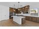 Spacious kitchen with dark wood cabinets, a large island, and stainless steel appliances at 37520 W Padilla St, Maricopa, AZ 85138