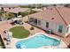 Backyard oasis with a kidney-shaped pool, putting green, and covered patio at 17750 W Pershing St, Surprise, AZ 85388