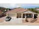 Tan house with two-car garage and desert landscaping at 17750 W Pershing St, Surprise, AZ 85388