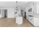 Open concept kitchen with white cabinets, island, and stainless steel appliances at 37645 W Padilla St, Maricopa, AZ 85138
