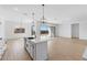 Bright kitchen with white cabinets, island, and sliding door access to backyard at 37645 W Padilla St, Maricopa, AZ 85138