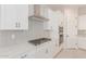 Modern kitchen with white cabinets, gas cooktop, and double oven at 20230 W Hollyhock St, Buckeye, AZ 85396