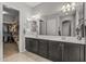 Bathroom with double vanity, large mirror, and access to walk-in closet at 26568 W Cat Balue Dr, Buckeye, AZ 85396