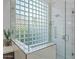 Shower with glass enclosure and a glass block window at 11905 N 83Rd Pl, Scottsdale, AZ 85260