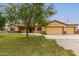 Single story house with three car garage and landscaped lawn at 25843 W Northern Lights Way, Buckeye, AZ 85326