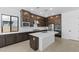 Modern kitchen with dark cabinets, white countertops, and an island at 37607 W Padilla St, Maricopa, AZ 85138