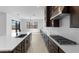 Modern kitchen with island, stainless steel appliances, and white backsplash at 37607 W Padilla St, Maricopa, AZ 85138