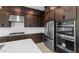 Modern kitchen with stainless steel appliances and dark wood cabinets at 37607 W Padilla St, Maricopa, AZ 85138