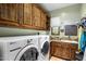 Bright laundry room with washer, dryer, and ample wood cabinets at 18826 N 101St Pl # 10, Scottsdale, AZ 85255