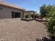 Backyard with gravel, covered patio, and mature desert landscaping at 20234 N Mariposa Way, Surprise, AZ 85374