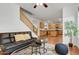 Living room features hardwood floors, a black couch, and a ceiling fan at 3260 E Mead Dr, Gilbert, AZ 85298