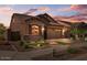 House exterior at dusk with landscaping and garage at 23148 E Carriage Way, Queen Creek, AZ 85142
