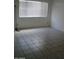 Empty living room with tiled floors and large window at 9627 W North Ln # B, Peoria, AZ 85345