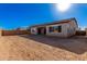 Backyard with a covered patio, dirt, and a bright sunny sky at 21726 E Lords Way, Queen Creek, AZ 85142