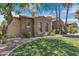 Stone house with palm trees, manicured lawn, and landscaping at 4327 E Capricorn Pl, Chandler, AZ 85249