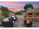 Cozy outdoor patio with a stone fireplace and fire pit at 3852 E Expedition Way, Phoenix, AZ 85050