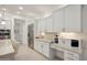 White kitchen with built in coffee bar and stainless steel appliances at 3852 E Expedition Way, Phoenix, AZ 85050