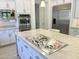 Stainless steel gas cooktop on large kitchen island with marble countertop at 3852 E Expedition Way, Phoenix, AZ 85050