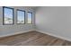 Simple bedroom with wood-look flooring and large windows at 26761 S 181St Pl, Queen Creek, AZ 85142