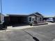 Gray manufactured home with carport, covered patio, and landscaped yard at 650 N Hawes Rd # 4507, Mesa, AZ 85207