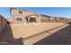 Exterior view of two-story home with dirt backyard enclosed by a wall at 21665 E Roundup Way, Queen Creek, AZ 85142