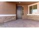 Front entryway with gray door, stone accents, and brick pavers at 21665 E Roundup Way, Queen Creek, AZ 85142