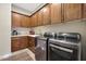 Bright laundry room with modern appliances and cabinetry at 12349 W Tyler Trl, Peoria, AZ 85383