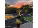 Backyard at sunset with putting green, waterfall feature, and desert plants at 12349 W Tyler Trl, Peoria, AZ 85383