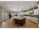 Open kitchen with large island, granite countertops, and white cabinets at 12349 W Tyler Trl, Peoria, AZ 85383