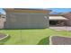 Landscaped backyard featuring a putting green and covered patio at 12349 W Tyler Trl, Peoria, AZ 85383