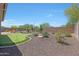 Landscaped backyard with putting green, desert landscaping, and a fire pit at 12349 W Tyler Trl, Peoria, AZ 85383