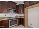 Kitchen with dark wood cabinets, granite countertops, and stainless steel appliances at 2127 E Huntington Dr, Phoenix, AZ 85040