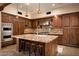 Spacious kitchen with dark wood cabinets, granite island, and high-end appliances at 38749 N 104Th Way, Scottsdale, AZ 85262