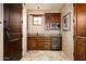 Wet bar with wood cabinets, granite countertops, and a mini-fridge at 38749 N 104Th Way, Scottsdale, AZ 85262