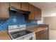 Kitchen with wood cabinets, blue tile backsplash, and electric cooktop at 1972 S Clubhouse Dr, Casa Grande, AZ 85194