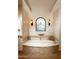 Spa-like bathroom with oval soaking tub, stained glass window, and tile flooring at 10728 E Cottontail Ln, Scottsdale, AZ 85255