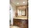 Clean bathroom with dark wood vanity, large mirror, and decorative tile at 10728 E Cottontail Ln, Scottsdale, AZ 85255