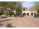 Spanish-style home with a large driveway and mature landscaping at 10728 E Cottontail Ln, Scottsdale, AZ 85255