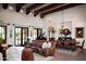 Open living and dining area with wood beams and fireplace at 10728 E Cottontail Ln, Scottsdale, AZ 85255