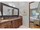 Double vanity bathroom with marble countertops and large mirror at 9926 E Kemper Way, Scottsdale, AZ 85255