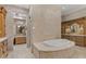 Spa-like bathroom with a large soaking tub, double vanities, and a walk-in shower at 9926 E Kemper Way, Scottsdale, AZ 85255