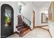 Grand staircase with wrought iron railing and arched entryway at 9926 E Kemper Way, Scottsdale, AZ 85255