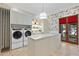 Bright laundry room with farmhouse sink and ample storage at 9926 E Kemper Way, Scottsdale, AZ 85255